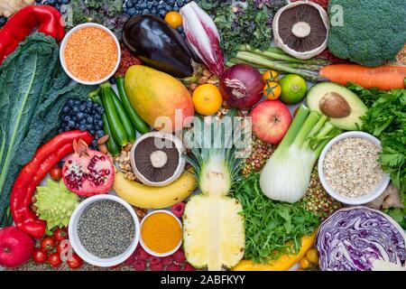 Vegane. Frutta Ortaggi lenticchie spezie erbe noci e semi su un bianco sullo sfondo di ardesia Foto Stock