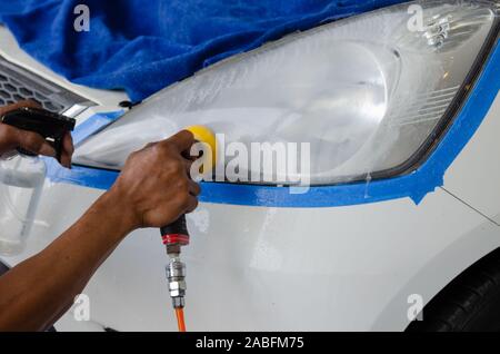 Mechanic la mano di lucidatura è la vettura del faro. Foto Stock