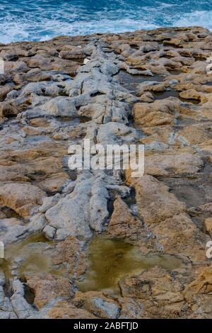 Dahlet Qorrot sull'isola di Gozo, Malta. Le falesie costiere sono parte di calcare e di parte di affioramento di origine vulcanica. Foto Stock