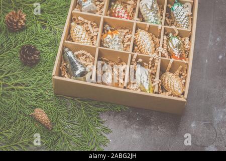 Bel vecchio vetro baubles di Natale in assortimento di colori e forme in una scatola di cartone, vista dall'alto, il fuoco selettivo Foto Stock