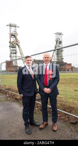 Clipstone, Nottinghamshire, Inghilterra, Regno Unito. 27th. Novembre 2019. Jonathan Ashworth (sinistra) del lavoro ombra del Segretario per la salute e Jerry aia (a destra), Sherwood Partito Laburista candidato visitare l'ex-comunità mineraria di Clipstone seguente lavoro di annuncio sul polmone specialista cliniche per i minatori pensionati. L'unico edificio rimasto in piedi a sinistra della miniera di carbone che è stato chiuso nel 2003 sono Il Grade ii Listed paletta, Europa più alti coal mining paletta a oltre 200 piedi. Credito: Alan Beastall/Alamy Live News Foto Stock