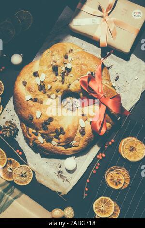 Appena sfornato rotolo chrismtas corona su un sfondo di legno con varie decorazioni natalizie Foto Stock