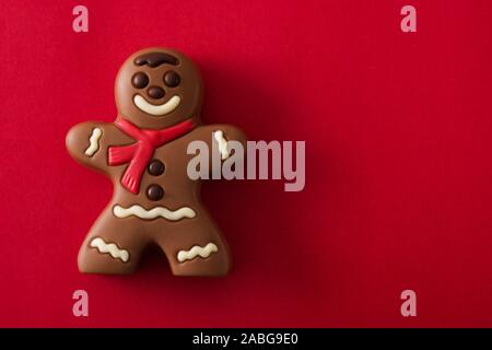 Il cioccolato di Natale gingerbread bonbon isolato su sfondo rosso. Spazio di copia Foto Stock