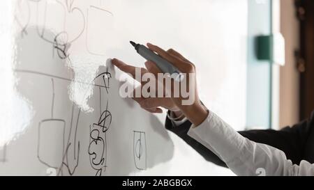 Diversi colleghi disegnare a bordo di brainstorming in office Foto Stock