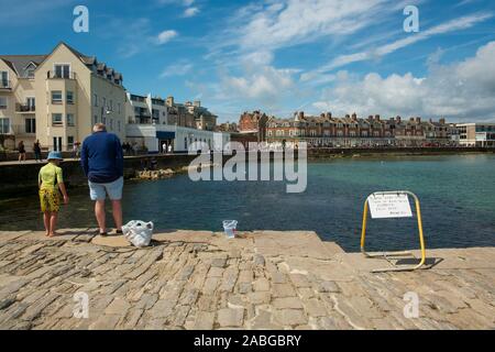 Sulla banchina a Swanage guardando attraverso la baia a mare Foto Stock