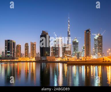 Skyline di torri si riflette nel torrente al crepuscolo in Business Bay in Dubai Emirati Arabi Uniti Foto Stock