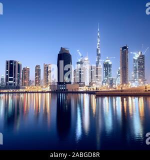 Skyline di torri si riflette nel torrente al crepuscolo in Business Bay in Dubai Emirati Arabi Uniti Foto Stock