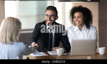 Multietnica sorridente datori di lavoro femminile di handshake richiedente al colloquio Foto Stock