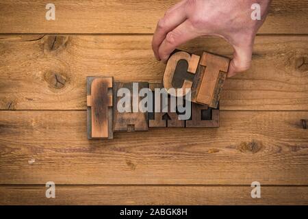 Fatto e falso concetto con vintage tipografia blocchi. Rimuovere a mano le lettere, svelando la giacciono al di sotto Foto Stock