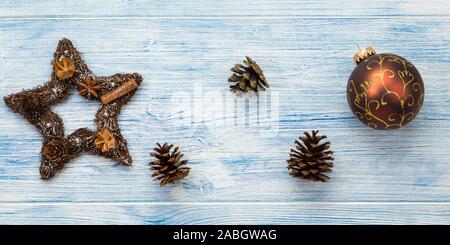 Banner di natale con pigne, ninnolo e stella su rustiche blu sullo sfondo di legno Foto Stock