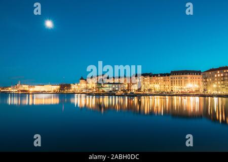 Helsinki, Finlandia. Vista del porto di polizia Merikasarmin Laituri e Laivastokatu Street a sera tarda serata luminarie. Foto Stock