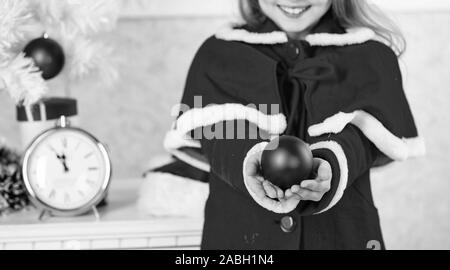 I bambini possono illuminare albero di natale creando i propri ornamenti. Pallina di natale decorazioni tradizionali. Top Natale che decora le idee per la stanza dei ragazzi. Bambino costume rosso tenere ornamento di Natale pallina. Foto Stock