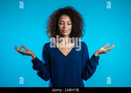 Calma ragazza studente o imprenditrice rilassante, meditando. La donna si placa, respira profondamente con mudra om. Foto Stock