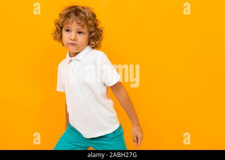 Unione i capelli rossi boy in una T-shirt bianco su sfondo giallo Foto Stock