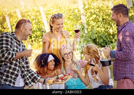 Happy amici la degustazione di vino in vigna - Giovani godendo del tempo insieme al di fuori in campagna - Gioventù amicizia e wine tour concept Foto Stock