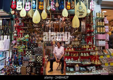 Istanbul: Turco venditore di strumenti musicali e di souvenir all'interno del Grand Bazaar, uno dei più grandi e più antiche mercati coperti in tutto il mondo Foto Stock