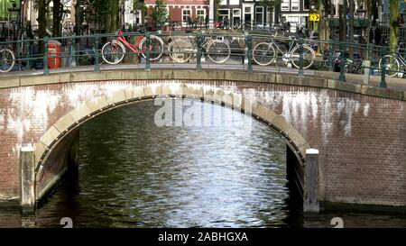 Biciclette incatenato ad un ponte su un canale in Amsterdam Foto Stock