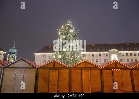 Magdeburg, Germania. 25 Nov, 2019. L'albero di Natale splende dietro le bancarelle del mercatino di Natale. Questo aveva aperto nel tardo pomeriggio e durerà fino al 30 dicembre 2019. Credito: Klaus-Dietmar Gabbert/dpa-Zentralbild/ZB/dpa/Alamy Live News Foto Stock