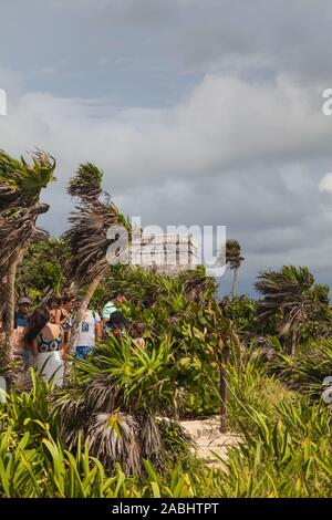 I turisti a piedi lungo il clifftop trail a Tulum rovine Maya sito in Messico Foto Stock