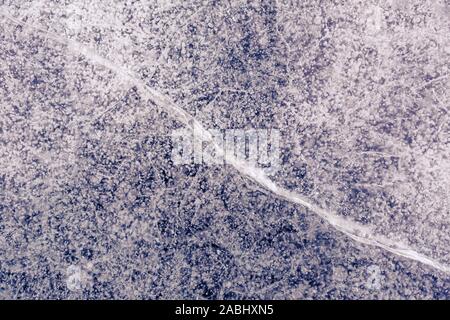 Bellissimo sfondo gelido con bolle congelate imprigionata nel ghiaccio. Vista infinita sulla superficie di stagno o lago. Foto Stock