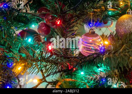 Colorate le luci fairy e baubles decorare un albero di Natale. Foto Stock