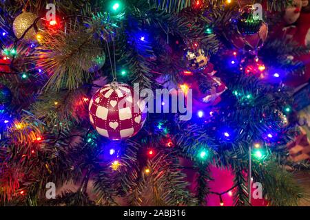 Colorate le luci fairy e baubles decorare un albero di Natale. Foto Stock