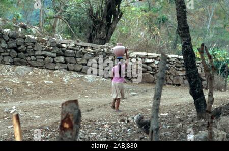 Un giovane, Chorti indigeni Maya ragazza porta acqua sulla testa. L'acqua dolce è una risorsa scarsa in Carrizalon, Honduras. Foto Stock