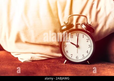 Sveglia sul letto a cuscino per dormire volte timer di attivazione del concetto. Foto Stock