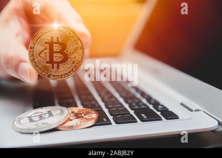 Bitcoin con computer portatile per denaro digitale o cryptocurrency nuova moneta virtuale il concetto di pagamento. Foto Stock