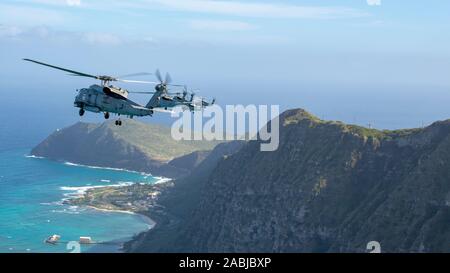 191126-N-XG173-1154 KANEOHE BAY, Hawaii (nov. 26, 2019) un MH-60R Sea Hawk elicottero, attaccato al 'Easyriders' di elicottero Maritime Strike Squadron (HSM) 37, volare in formazione intorno all'Isola di Oahu nov. 26. HSM 37, appostato al Marine Corps base Hawaii in Kaneohe Bay, è il più grande expeditionary squadron NEGLI STATI UNITI Navy e supporta tutti i Pearl Harbor-basato Arleigh Burke-class guidato-missle cacciatorpediniere e Ticonderoga-class guidato-missle incrociatori. (U.S. Foto di Marina di Massa Specialista comunicazione marinaio Aja B. Jackson) Foto Stock