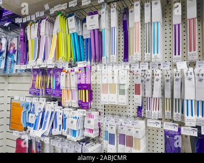 Aghi da maglia e crochet ganci sul display in un negozio di artigianato. Foto Stock