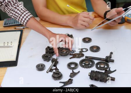 Ingegnere discutendo e progettazione circa la marcia meccanica parti in ufficio. Foto Stock
