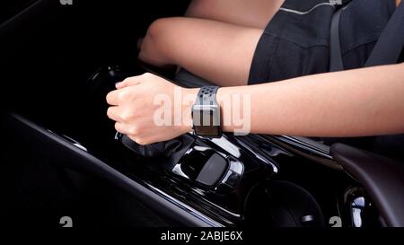 La mano della donna di cambiare marcia durante la guida di una vettura Foto Stock