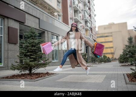 Felice giovane donna salta su strada Foto Stock