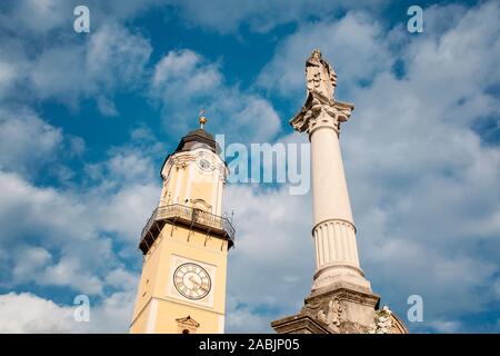 Vecchia Piazza principale di Banska Bystrica, Slovacchia, Europa Centrale. Clock Tower, colonna mariana nella giornata di sole. Cielo blu e nuvole in background. Foto Stock