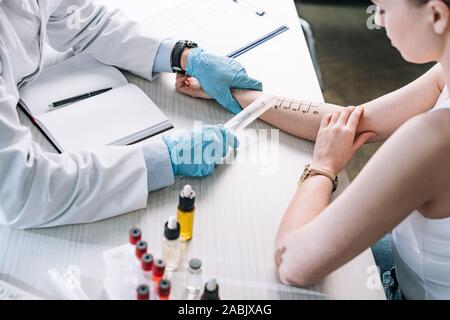 Vista aerea del allergist holding Righello marcato vicino a mano di donna Foto Stock