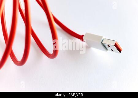 Close-up di red arricciata Cavo USB isolato su sfondo bianco con spazio di copia Foto Stock