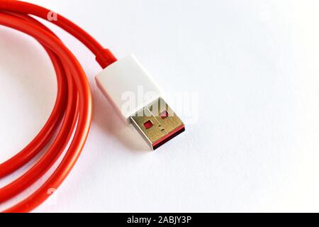 Close-up di red arricciata cavo USB su sfondo bianco Foto Stock