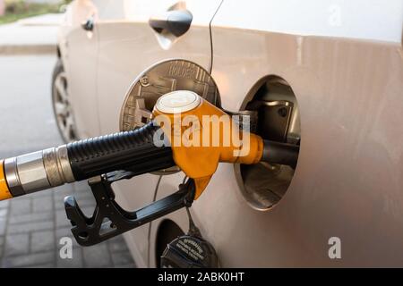 21-11-2019, Regione di Mosca, Russia. Aprire il carburante per auto serbatoio berlina con pompa di carburante, il rifornimento di un'auto a benzina in una stazione di benzina. Il rifornimento di carburante, self-servi Foto Stock