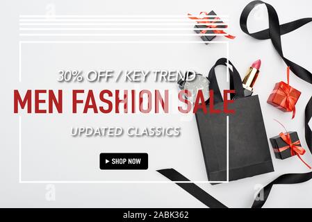 Vista superiore della piccola shopping bag con orologio maschio e femmina rossetto vicino a nastro e presenta su sfondo bianco con il 30 percento di sconto moda maschile s Foto Stock