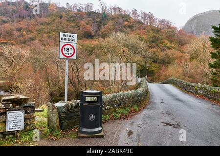 In pietra a secco debole ponte sul fiume Derwent presso il villaggio di Grange in The Borrowdale valley, Lake District, Cumbria, Inghilterra, in un giorno di pioggia. Foto Stock