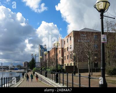 La gente che camminava sul marciapiede accanto al bacino di Ontario, Manchester Ship Canal, le banchine, Salford, Manchester, Inghilterra, Regno Unito Foto Stock