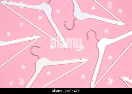Legno bianco appendiabiti sul rosa pastello con sfondo glitter stelle. Shopping, vendita, promo, social media, nuovo concetto di stagione Foto Stock