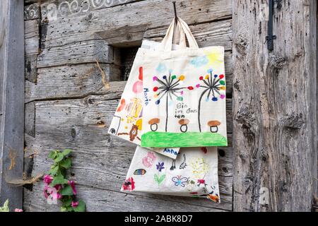 Sacchetti in tessuto decorato dai bambini appesi ad un chiodo in un rifugio alpino. Bavaria Foto Stock