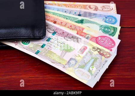 Denaro iracheno - Dinar nel portafoglio nero Foto Stock