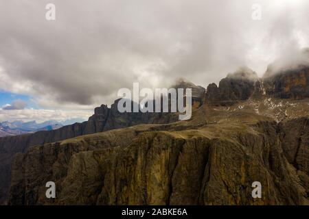 Vista aerea del Brunecker Turm, Sassolungo montagna e passo passo Gardena durante il tramonto. Dolomiti in Alto Adige Foto Stock