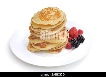Pila di fresco frittelle fatte in casa su una piastra con pochi acini su sfondo bianco Foto Stock