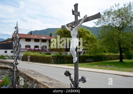 Un grave croce si erge sul cimitero davanti alla chiesa parrocchiale di San Remigius in Schleching. [Traduzione automatizzata] Foto Stock