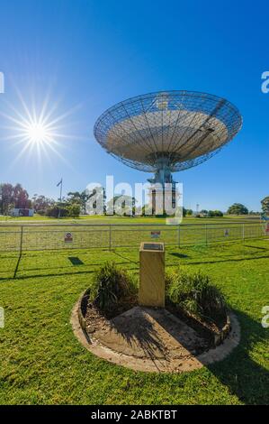 Parkes radio Telescope Observatory, cielo blu sunstar burst, verde, erboso, giardini e telescopio rivolto verso l'alto nel nuovo Galles del Sud, Australia. Foto Stock