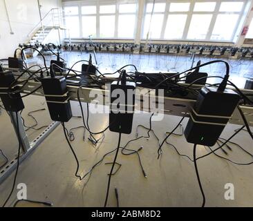 Numerosi sono i dispositivi di ricarica sul livello di locali dove la scooter elettrici sono cariche di notte. [Traduzione automatizzata] Foto Stock